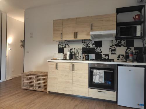 a kitchen with wooden cabinets and black and white wallpaper at Casa Felix in Giulianova