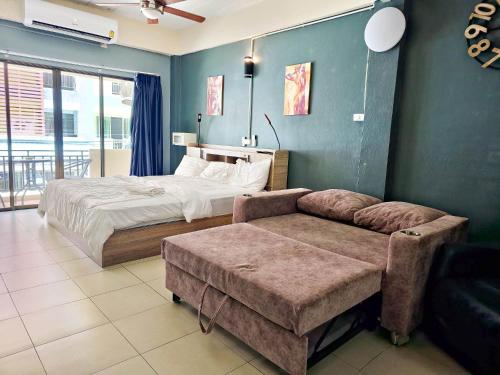 een slaapkamer met een bed en een bank erin bij Nieuw Vlaanderen in Pattaya