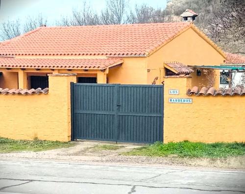 una casa amarilla con una puerta azul delante de ella en Casa rural Los Barreros en Ciudad-Rodrigo
