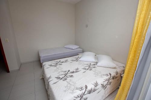 a small room with two beds and a mirror at Sobrado com Piscina - Pontal do Parana in Pontal do Paraná
