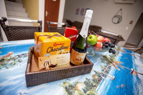 a table with a bottle of champagne and some fruit at Sobrado com Piscina - Pontal do Parana in Pontal do Paraná