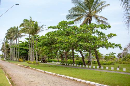 a cobblestone street with palm trees in a park at Sobrado com Piscina - Pontal do Parana in Pontal do Paraná