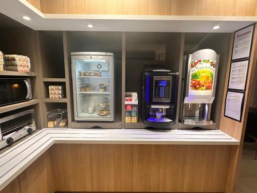 a kitchen with a refrigerator and a microwave at Première Classe Paris-Ouest Gennevilliers in Gennevilliers