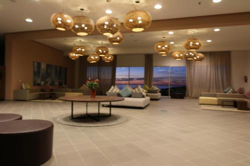 a lobby with couches and a table and chandeliers at Lunja Village - Agadir in Taghazout