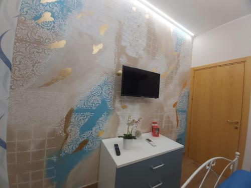 a bathroom with a wall with a tv on it at Casa vacanze - "O Tunnu" in Avola