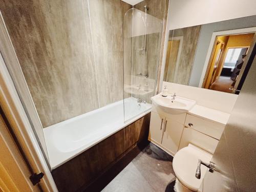 y baño con aseo, lavabo y ducha. en 3 Bedroom Apartment in the Heart of Newcastle - Modern - Sleeps 6 en Newcastle