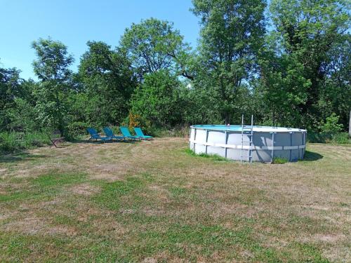 a group of blue chairs sitting in a field at Camping La cour d'Enchère in Saint-Palais