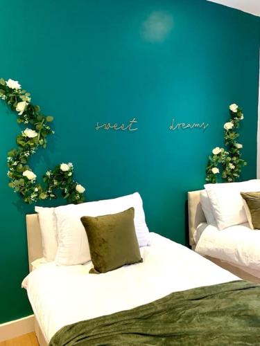 Elegant 3 bed flat with Parking في بورتسماوث: غرفة نوم بسريرين وجدار ازرق