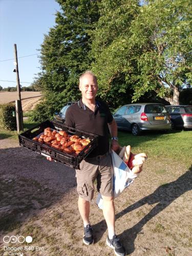 a man is holding a tray of chickens at Camping La cour d'Enchère in Saint-Palais