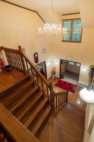 a staircase in a living room with a chandelier at Private hot-spring Villa in Nasu in Nasu