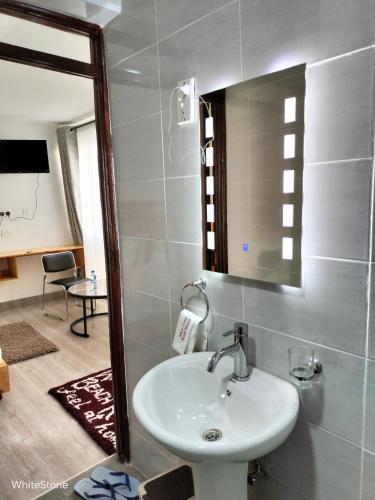 a bathroom with a sink and a mirror at White Stone Beach Resort in Mbita