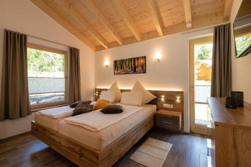 a bedroom with a large bed in a room with windows at Haus Sternenblick in Drachselsried