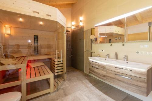 ein Badezimmer mit einer großen Badewanne und einem Waschbecken in der Unterkunft Haus Sternenblick in Drachselsried