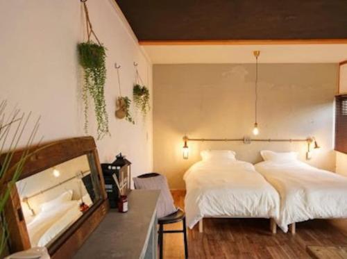 A bed or beds in a room at (旧信濃Natural)新規オープン！深呼吸したくなるゲストハウス。長野駅前徒歩8分！