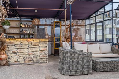 eine Terrasse mit 2 Korbstühlen und einer Bar in der Unterkunft Villa Tulipan in Antalya