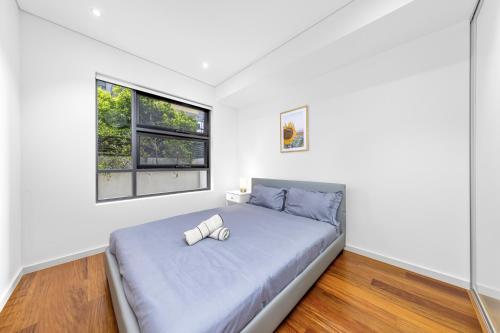 a bedroom with a large bed with a window at Super comfy 2B Apt in Burwood in Sydney