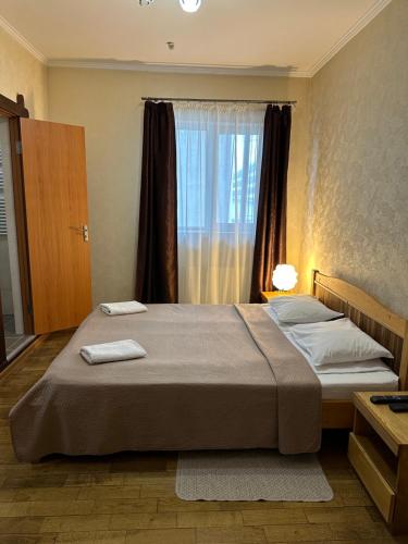 sypialnia z dużym łóżkiem i oknem w obiekcie Гранд Хостел w Czerniowcach