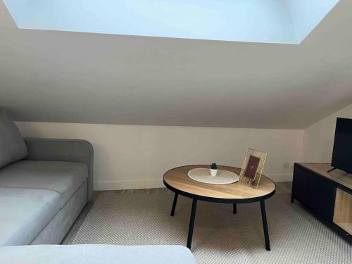 - un salon avec une table et un canapé dans l'établissement Duplex Place du Martroi, à Orléans