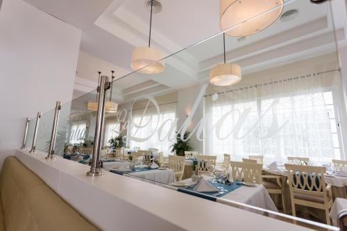 a dining room with tables and chairs and mirrors at Bahia Principe Luxury Bouganville - Adults Only All Inclusive in La Romana