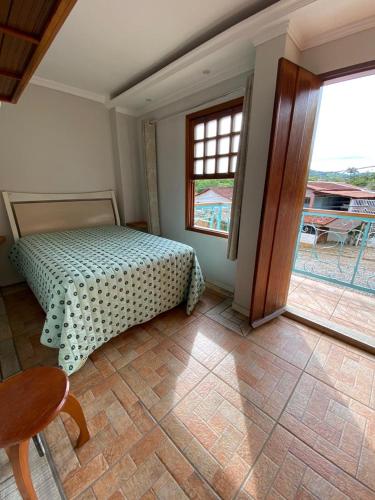 ピレノポリスにあるQuinta Da Estalagemのベッドルーム1室(ベッド1台、テーブル、窓付)