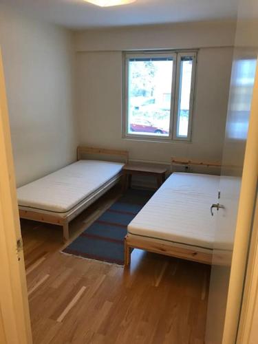 twee bedden in een kleine kamer met een raam bij BlåKlinten in Mariehamn