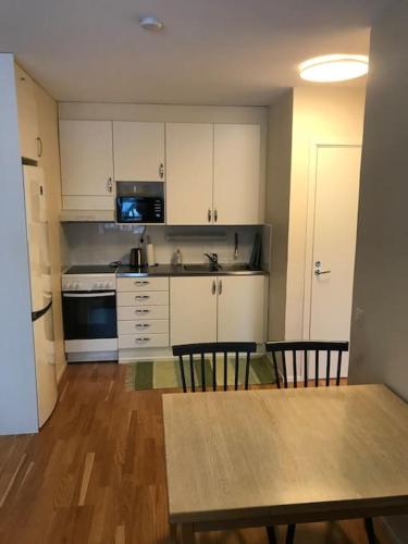 a kitchen with white cabinets and a table and chairs at BlåKlinten in Mariehamn