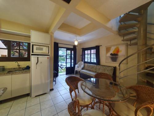 a kitchen and living room with a table and chairs at Villa Garoupeta - Apartamentos in Bombinhas