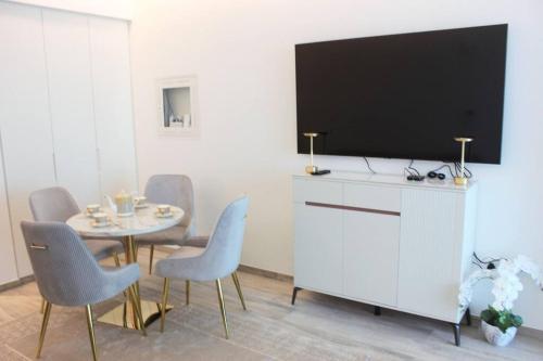 a living room with a table and a tv on a wall at Розкішна квартира з видом на Бурж Халіфа in Dubai