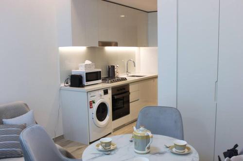 a kitchen with a table and chairs and a microwave at Розкішна квартира з видом на Бурж Халіфа in Dubai