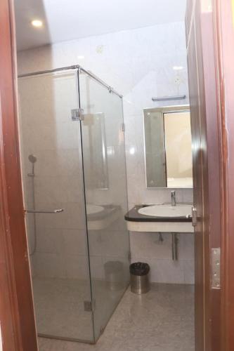 a bathroom with a glass shower and a sink at Elgozo Hotel Dreams Parasise in Yercaud