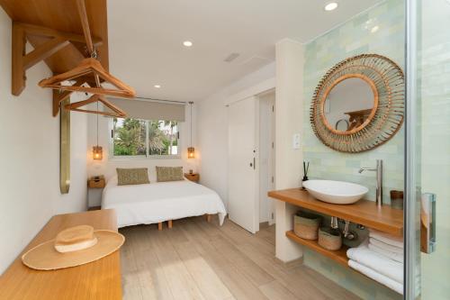 ein Bad mit einem Bett, einem Waschbecken und einem Spiegel in der Unterkunft Mangata Gran Canaria - Adults Only in San Agustín