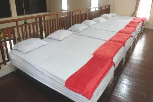 fila de camas con sábanas y almohadas rojas en OYO 93595 Puri Adem 86 Syariah Bunkbed en Yogyakarta