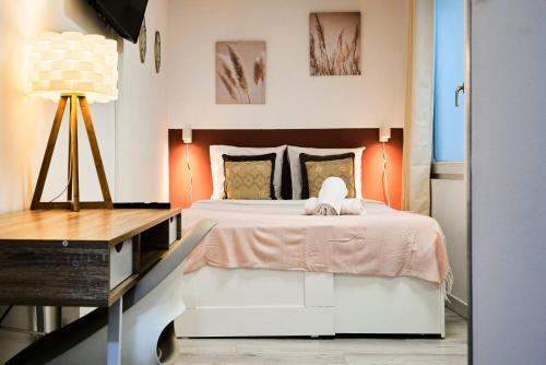 ein Schlafzimmer mit einem Bett und einem Tisch mit einer Lampe in der Unterkunft Large studio between train station & Grand Place in Lille
