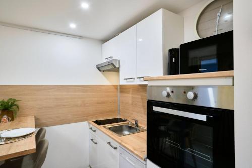 a small kitchen with a sink and a microwave at Large studio between train station & Grand Place in Lille