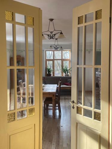 a dining room with a table and glass doors at Ielejas A place for cool living in Vircava
