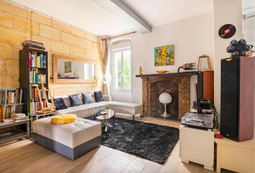 un salon avec un canapé et une cheminée dans l'établissement Chambre privée avec salle de bain dans la Maison Noble de la Taule du Luc, à Eysines