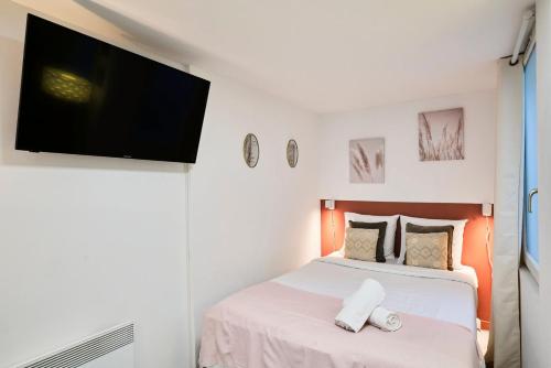a bedroom with a bed with a flat screen tv on the wall at Large studio between train station & Grand Place in Lille