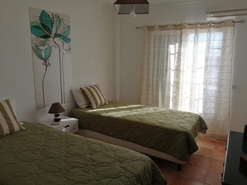 a bedroom with two beds and a window at Apartamento Vista Mar in Cabanas de Tavira