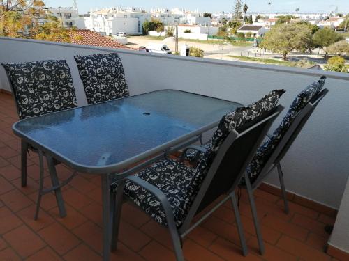 a glass table and two chairs on a balcony at Apartamento Vista Mar in Cabanas de Tavira