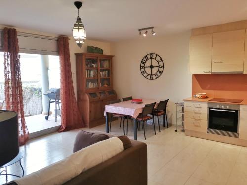 ein Wohnzimmer mit einem Sofa und einem Tisch mit Stühlen in der Unterkunft Apartament a les cales de Llançà en residència privada amb piscina in Llança