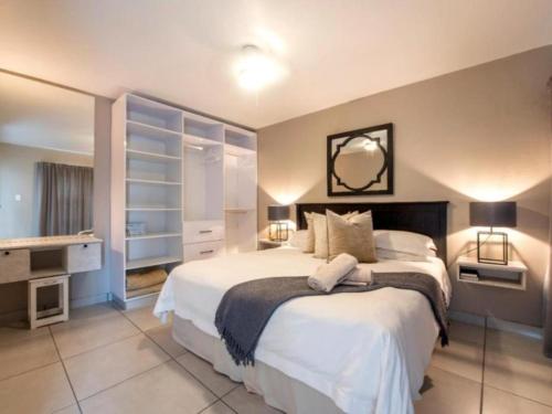 a bedroom with a large bed and a desk at Kelly's Beachfront Apartments in Port Alfred
