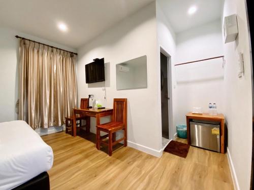 a hotel room with a bed and a desk and a table at โรงแรม ต้นสัก เลย รีสอร์ท Tonsak Loei Resort&Hotel in Wang Saphung