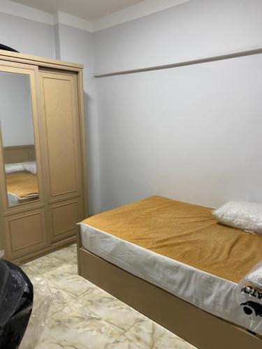 1 dormitorio con cama y espejo en وسط كل شئ, en El Cairo