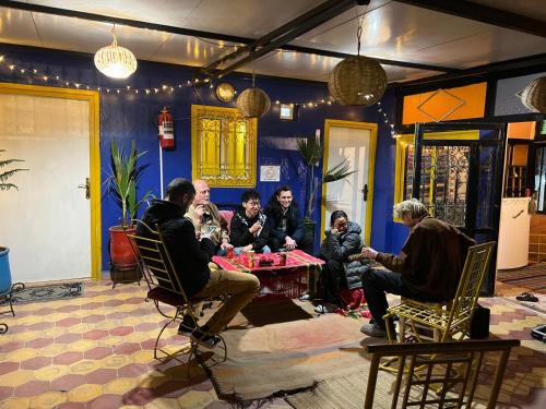 een groep mensen die rond een tafel in een kamer zitten bij Riad dar sahrawi in Marrakesh
