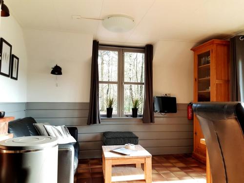 a living room with a couch and a window at Tiny House de Berken in Otterlo