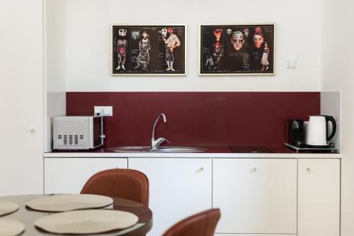 uma cozinha com uma mesa e algumas imagens na parede em Classy Old Town Suites na Cracóvia