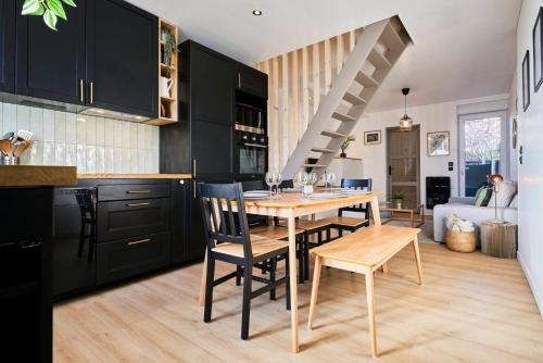 eine Küche mit schwarzen Schränken sowie einem Holztisch und Stühlen in der Unterkunft Two bedroom house with courtyard, quiet in Saint-André