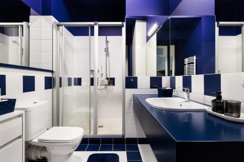 a blue and white bathroom with a toilet and a sink at Classy Old Town Suites in Krakow