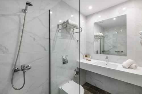 e bagno con doccia, servizi igienici e lavandino. di Arte hotel a Città di Rodi