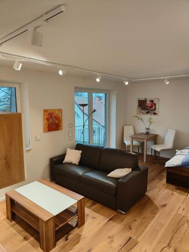 a living room with a black couch and a table at Ferienwohnungen - barrierefrei - im sanierten Gutshof in Lalendorf